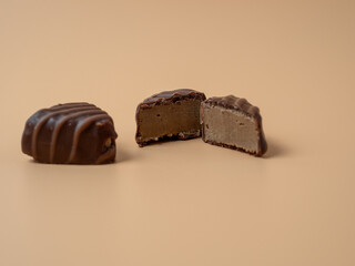 Chocolate candies on an orange background. Chocolate candies close-up.