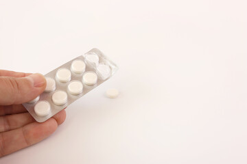 A man holds flu and cold pills in his hand. Treatment of acute respiratory diseases.