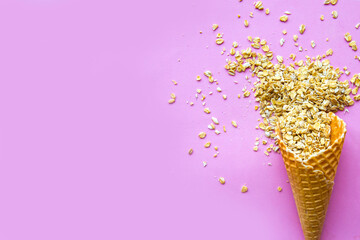 raw oat-flakes on pink background and ice cream cone