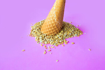 raw oat-flakes on pink background and ice cream cone