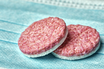 two large white-pink pills, photographed close-up.