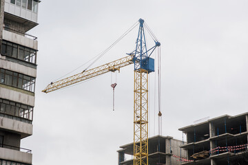 A large crane is building a new building in Ukraine against the sky. Restoration after the war....