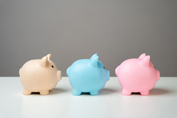 Three piggy banks lined up in a chain. Savings management. Reinvest part of the profits. Dividing...