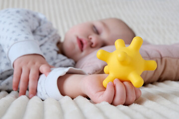 A baby is sleeping in a crib, a child of European appearance, wearing a light light jumpsuit. A...