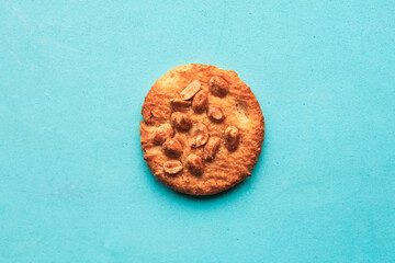 Tasty round cookies with nuts on blue background, top view, minimal
