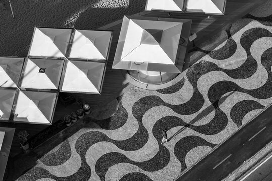 Copacabana Beach, Rio De Janeiro, Brazil. Traditional Sidewalk, Kiosk And Bike Path. Someone Walking In The Morning. Black And White Image.