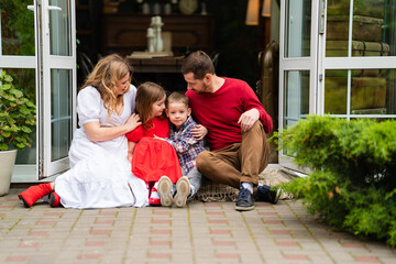 Beautiful and happy family on the porch of the house. 