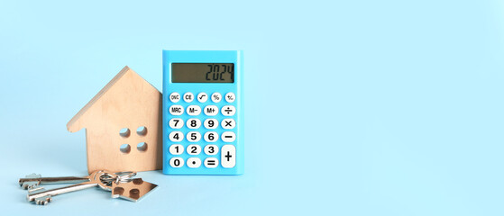 Calculator, figure of house and keys on light blue background with space for text