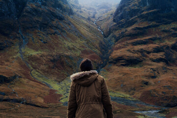 Traveler looking at Glen Coe Valley in Scotland, cinematic scene from the Higlands, Scotland tourism