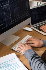 Male programmer working with computer at table in office, closeup