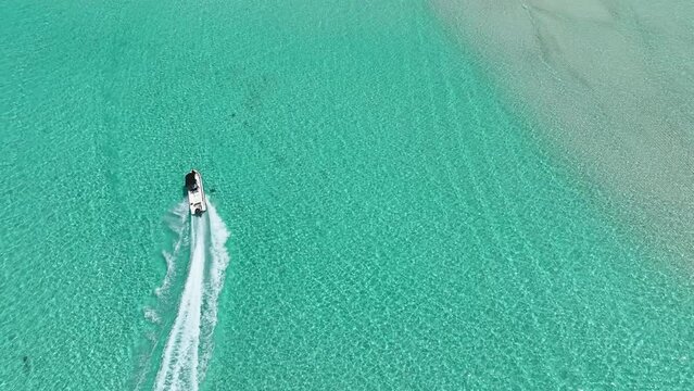 Aerial bliss is experienced aboard a high-speed boat with clear waters and captivating views, featuring a beautiful woman on the boat