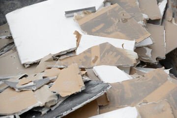 dumpster waste container with construction waste and drywall plasterboard, debris generated during...
