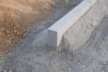 Concrete curb border laid on cement. road safety Pavement construction material, work
