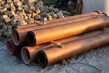 Heap of ceramic sewer drainage pipe on construction site. Digged New infrastructure, supply systems