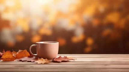 Fototapeten wooden tea cup on top of light brown wood table with autumn leaves frame shoot from front view with  © nawaitgraph