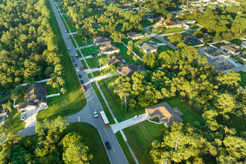 Aerial view of american yellow school bus picking up children at sidewalk bus stop for their lessongs in early morning. Public transportation in the USA