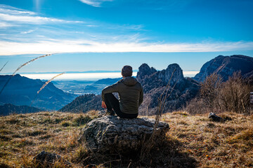 Mountaineer admiring the landscape of Valsassina from Piani Resinelli plain
