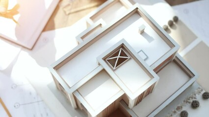Male architect holding and working on model of architectural house top view - Powered by Adobe