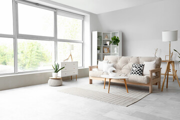 Interior of light living room with cozy sofa and white furniture - Powered by Adobe