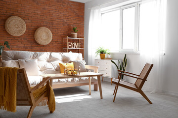 Interior of stylish living room with white sofa, armchairs and fruit basket on coffee table