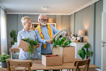 Senior couple man and woman husband wife pack or unpack boxes moving