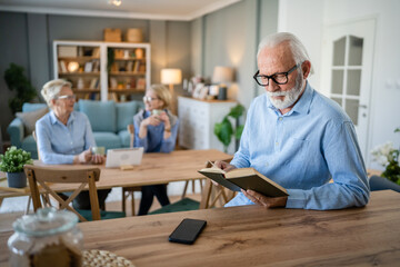Fototapeta na wymiar Senior man mature caucasian male read book at home wear eyeglasses