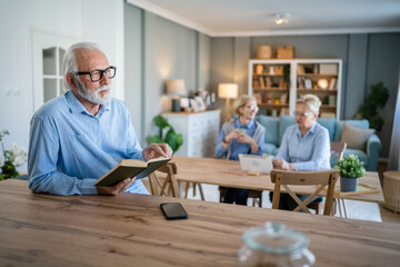 Senior man mature caucasian male read book at home wear eyeglasses
