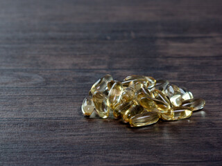 Closeup of a lot of omega 3 oil capsules on a wooden background. The concept of natural and healthy nutrition.