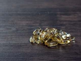 Closeup of a lot of omega 3 oil capsules on a wooden background. The concept of natural and healthy...