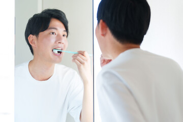 歯ブラシで歯を磨く男性 - obrazy, fototapety, plakaty