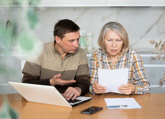 Man and woman are outraged by the increase in utility bills, checking the data on the management...