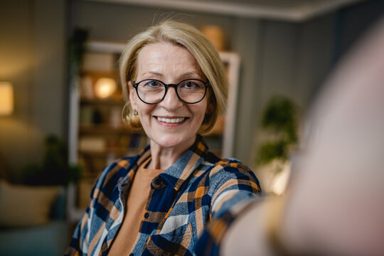 Portrait of one mature blonde caucasian woman with eyeglasses at home