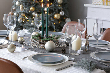Christmas table setting with burning candles and beautiful decorations