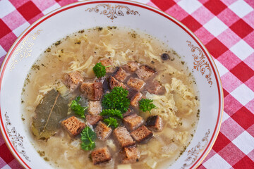 Close up picture of strong and healthy garlic soup, significant example of the dish from cuisine of Czech republic. Soup is made from broth, poatoes, garlic and mashed eggs, parsley and bread crumbs.