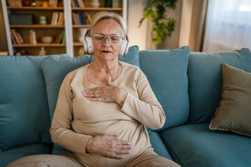 Mature senior woman practice guided meditation manifestation at home
