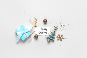 Gift box, card with text MERRY CHRISTMAS and different decorations on grey background