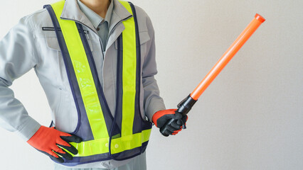 誘導棒を持つ作業服の男性｜建設業・警備員・ガードマン　イメージ