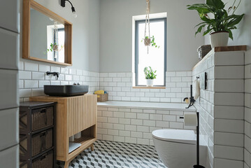 Modern bathroom interior with window, bath, white tiles on the wall and sink on the wooden cabinet...