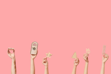 Female hands with different wooden toys, decorative door and mini ladder on pink background