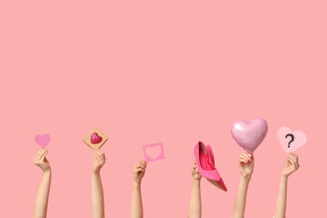 Female hands with paper hearts, high heels and gift box on pink background. Valentine's Day...