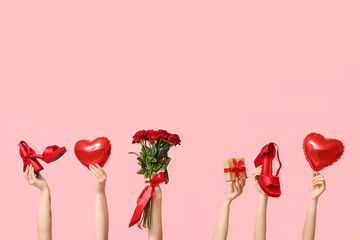 Female hands with bouquet of roses, high heels and balloons on pink background. Valentine's Day...