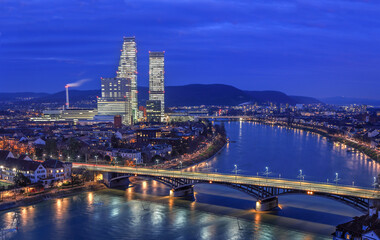 Night cityscape of the Swiss city Basel over the Rhine river with street lights and high rise...