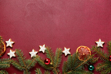 Delicious stars shaped Christmas cookies with fir branches and balls on brown background