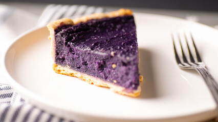 Purple yam pie on a white ceramic plate.
