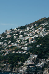 Amalfi Sea Coast with Umbrellas, people swim, and Yachts. Clean and blue sea where to swim. Photo for tourism and summer background. Concept of vacation and beach life in the open air   colorful