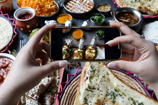 Hands of a blogger taking a photo of food with a smartphone