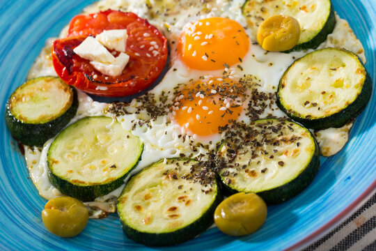 Fried eggs with zucchini and tomato is tasty dish in the kitchen.