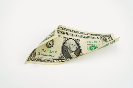 A twisted US one dollar bill on a white background,  horizontal position.