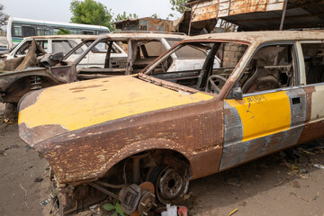 Carcasse de vieille voiture abandonnée dans une rue d'un village africain