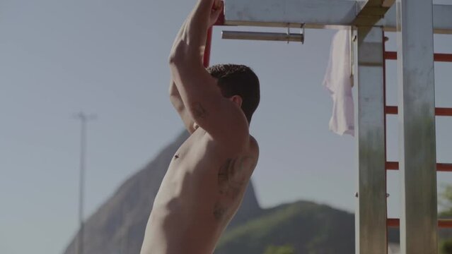 Strong young man exercising outdoors in Rio de Janeiro, Brazil. Cinematic 4k.